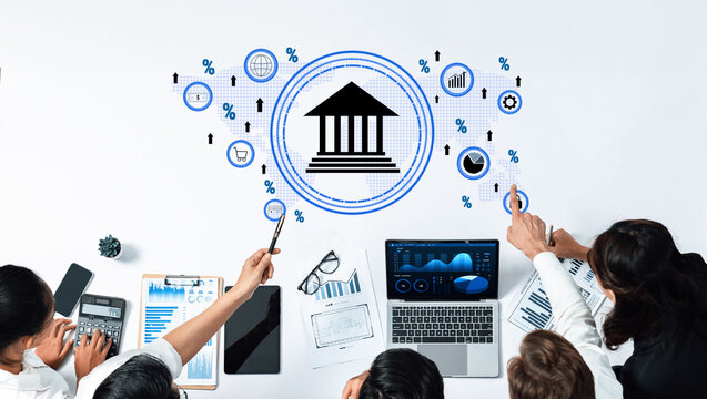 A diverse team analyzes financial data on a modern workspace with visual aids like charts and graphs while using digital technology to drive business strategy. Trope