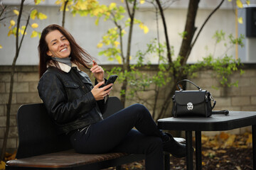 Happy Stylish Woman in Leather Jacket on City Street