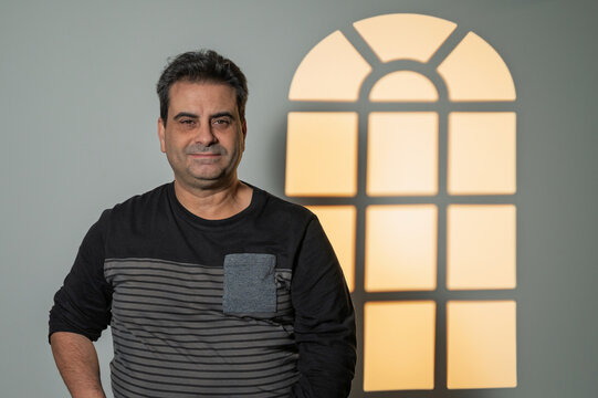 Mature man smiling receiving window light shadow - Powered by Adobe