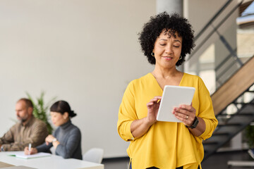 Portrait of a group of young business people having a meeting or training in the office. Teamwork and success concept, portrait of a smart young businesswoman, student, teacher or coach holding a tabl © Lumos sp