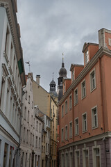 Fototapeta premium A view of old buildings with ornate architecture and domed towers under a cloudy sky in Riga, Latvia