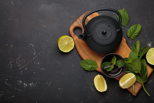 Black cast iron teapot refreshing mint lime herbal tea fresh relax healthy detox copy space - Powered by Adobe