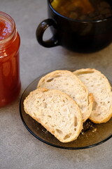 Butter, cranberry red jam and cup of hot tea on a table