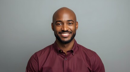 Confident portrait of a smiling young adult man in a maroon shirt against a clean neutral background, showcasing modern professional style, friendly expression, and studio lighting ideal for business 