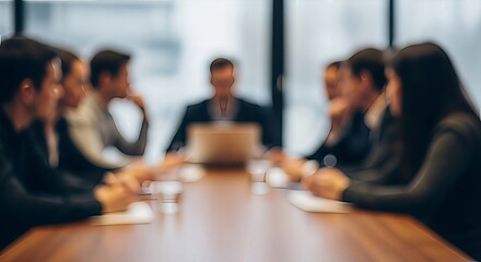 Blurred corporate team at boardroom table in a meeting discussing business strategies