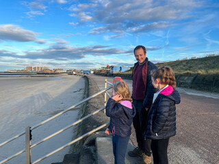 Father and Daughters Talking by the Beach