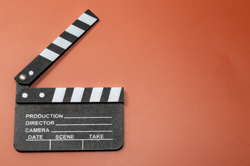 Clapperboard on an orange background, representing filmmaking and the start of a movie.