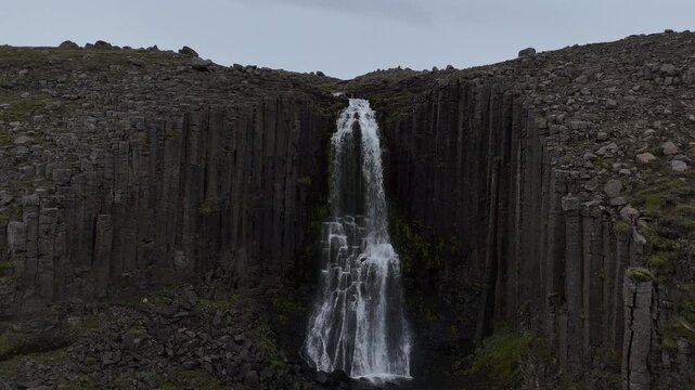 Aerial Litlanesfoss basalt waterfall Iceland
Drone view of Litlanesfoss waterfall cascading between tall, dark basalt columns in a rugged green canyon in Iceland, 2025
