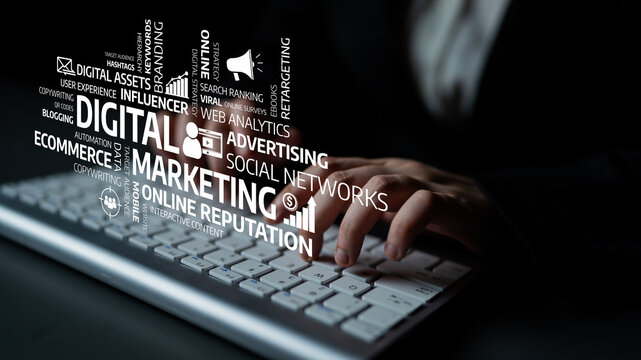 Focus on a keyboard with hands typing and surrounded by digital marketing words, illustrating the importance of online presence and strategic growth for businesses. Tessel