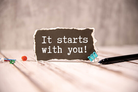 Naklejki A window is made in the paper, where on a yellow background the inscription - It Starts With You.