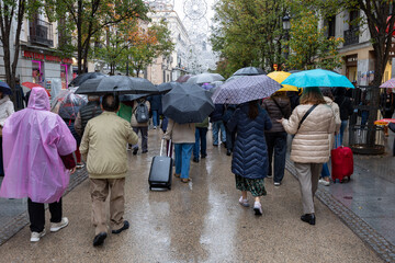 City pedestrians walking on street during autumn rain