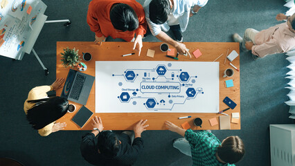 A diverse team collaborates in a modern workspace, utilizing cloud computing visuals and technology tools for innovative brainstorming and strategic planning. Amity