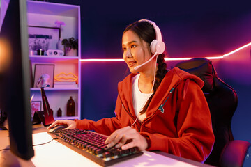 Host channel of smiling beautiful Asian girl streamer playing online game wearing headphone talking...
