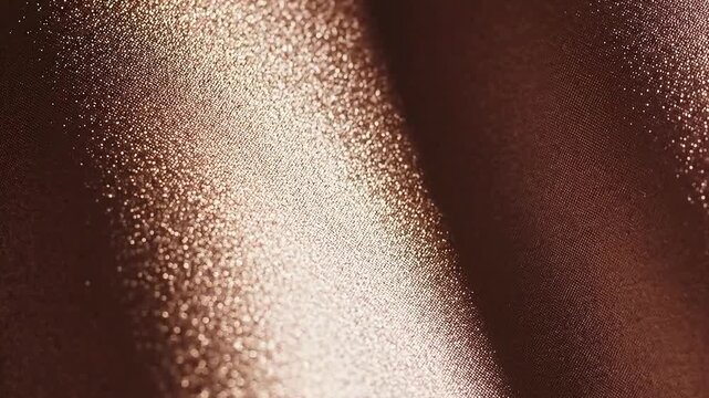 Close up detailed texture of shimmering metallic rose gold fabric with subtle wave pattern and soft studio lighting