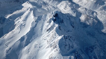 Snow-Covered Mountain Peaks Under Clear Blue Sky in Majestic Winter Landscape with Dramatic Shadows and Highlights