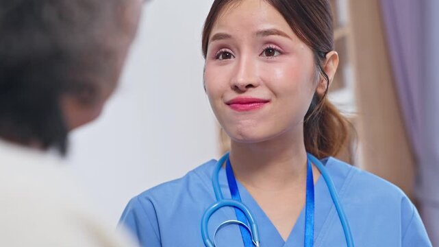 Asian compassionate nurse speaking with elderly patient showing attentive care and conversation clinic elderly care nurse with stethoscope uniform provides medical support and emotional comfort