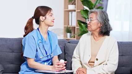 Asian nurse caregiver home consultation with elderly patient discussing medication and care plan using stethoscope and clipboard compassionate support during at home medication explanation