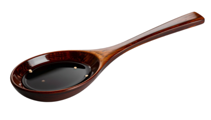 Dark liquid in wooden spoon, isolated on black background