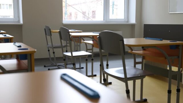 Stylish classroom with desks and chairs at school. Camera moving left