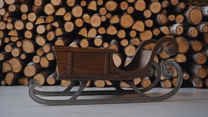 Rustic Wooden Sleigh with Metal Runners Against a Stack of Firewood. - Powered by Adobe
