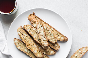 Overhead view of almond biscotti on a white plate, top view of almond cantucci on white background
