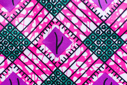 close up view of pink ankara fabric, flatlay of nigerian wax cloth with designs, spread out pink ankara material