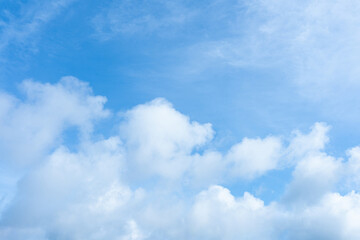 Bright blue sky with scattered white cumulus clouds filling the frame from below