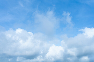 Bright blue sky with bright white and grey cumulus clouds filling the lower portion