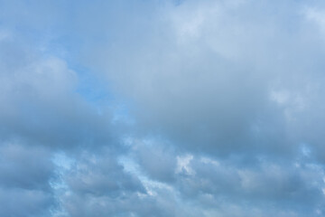Overcast sky filled with layers of thick blue gray cumulus clouds against a lighter blue background
