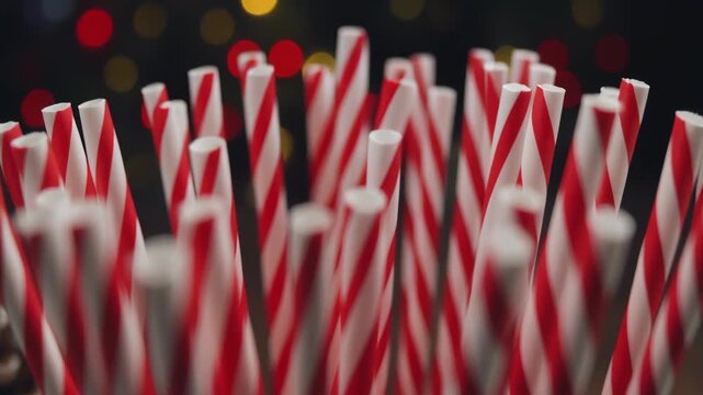 Closeup of candy canes with blurred Christmas lights in the background creating a festive and sweet holiday atmosphere.