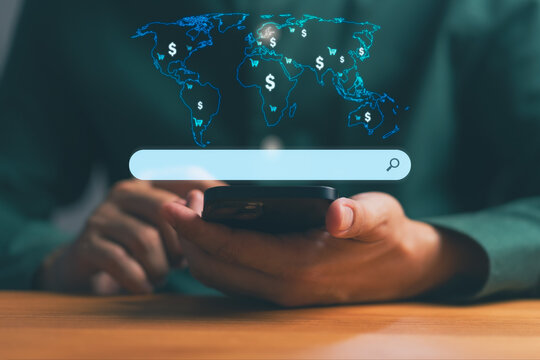 Person using smartphone with world map and dollar icons on search bar, symbolizing global online business, e-commerce opportunities, digital market, financial research, and worldwide economic trend.