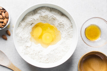 overhead view of almond biscotti dough being mixed in a white bowl, flatlay of biscotti cookie dough or twice baked cookie dough