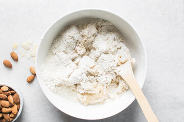 overhead view of almond biscotti dough being mixed in a white bowl, flatlay of biscotti cookie dough or twice baked cookie dough