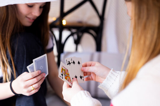 Young girls playing cards inside makeshift tent inside the house