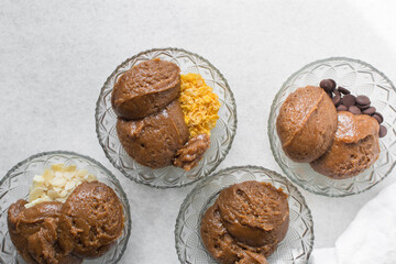 Overhead view of giant chocolate chip cookie dough in glass bowls, chocolate chip cookie dough in a small mixing bowl