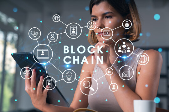 Smiling businesswoman in casual wear holding tablet device touching it at office workplace. Concept of distant work, business education, information technology.Blockchain hologram