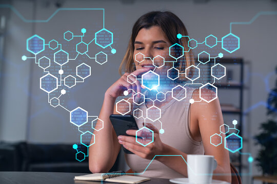 Smiling businesswoman in casual wear holding using smartphone typing at office workplace with notebook. Concept of distant work, business education. Blockchain crypto hologram