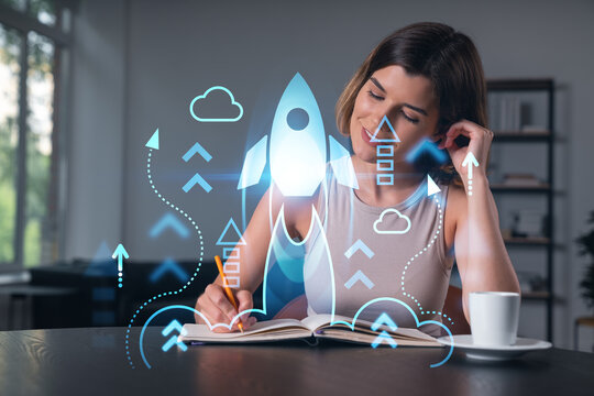 Smiling woman in casual wear taking notes in notebook at office workplace with coffee cup. Concept of distant business education, information technology, dreaming, thinking. Start up drawings