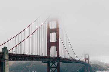 Golden Gate Bridge emerging through layers of soft morning fog.