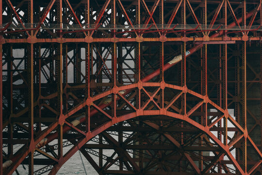 Close-up steel structure details of the Golden Gate Bridge on a foggy day.