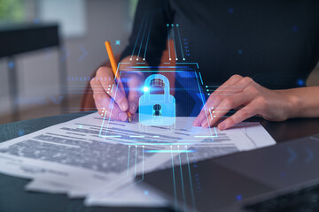 Businesswoman in formal wear taking notes signing contract at office workplace. Concept of important working moments, document sign, working process, concentration. Hands shot. Lcok icon hologram