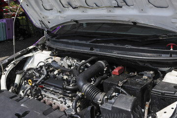 White car engine with an open hood for maintenance and repair service. Automotive vehicle motor...