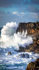 Crashing waves explode against rugged cliffs under a cloudy sky