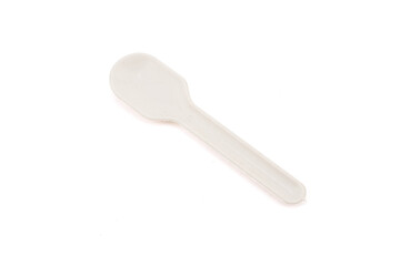Close-up of a small white plastic spoon on a plain background.