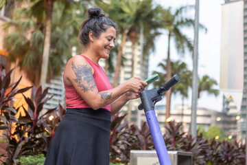Woman unlocking electric scooter with smartphone in Kuala Lumpur