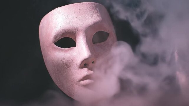 A textured mask emerges from misty fog, floating against a dark backdrop, mysterious and surreal