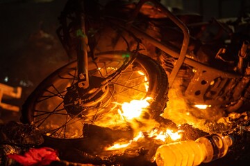 Bike tires on fire in the night with large flames