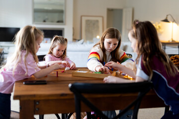 Young girls playing colourful rectangular blocks on the table