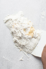 Overhead view of pasta dough being mixed on a white granite countertop, process of making homemade pasta dough