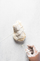 Overhead view of pasta dough being mixed on a white granite countertop, process of making homemade pasta dough
